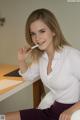 A woman sitting at a desk smoking a cigarette.